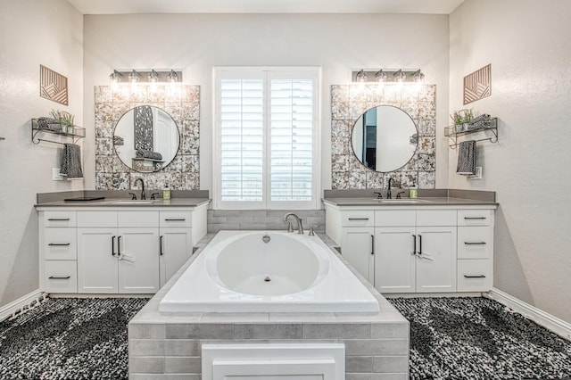 full bath with a garden tub, two vanities, and a sink