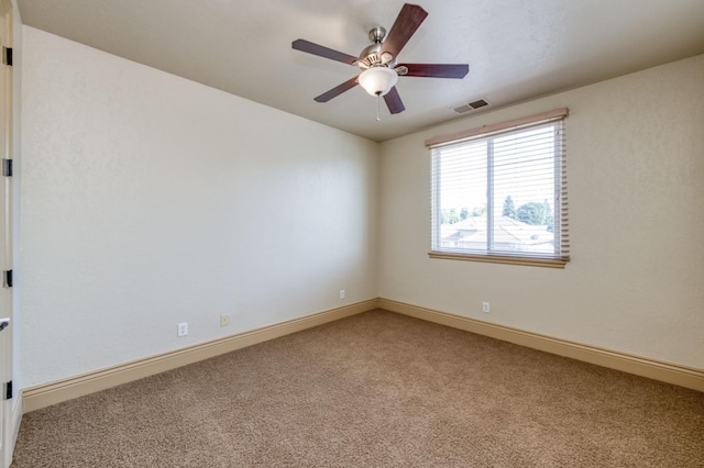 spare room featuring visible vents, ceiling fan, light carpet, and baseboards