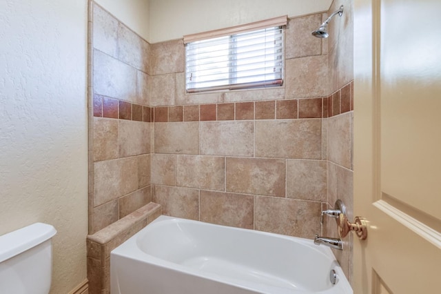 full bathroom featuring  shower combination, a textured wall, and toilet