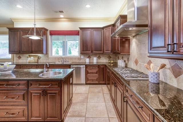 kitchen with appliances with stainless steel finishes, visible vents, a sink, and wall chimney exhaust hood