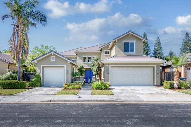 traditional-style home with a garage, concrete driveway, and fence