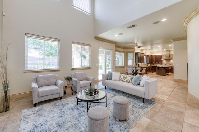 living area featuring visible vents, crown molding, baseboards, and light tile patterned floors