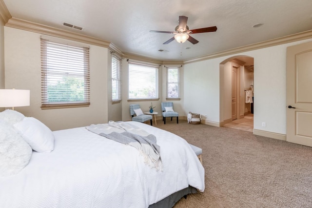 bedroom featuring arched walkways, light colored carpet, visible vents, baseboards, and ornamental molding