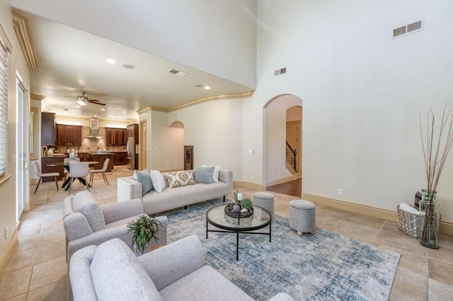 living area featuring arched walkways, visible vents, and light tile patterned flooring