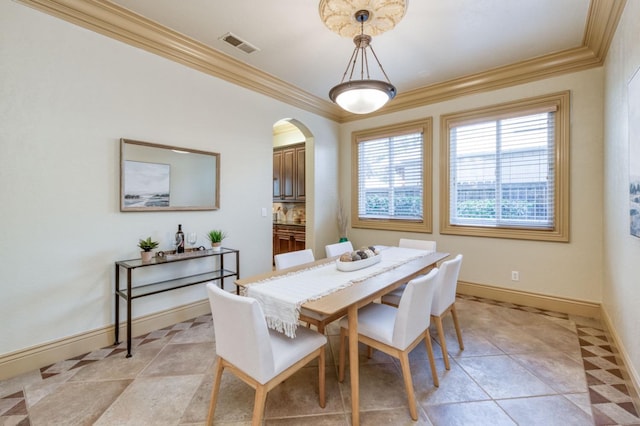 dining room featuring arched walkways, light tile patterned floors, visible vents, ornamental molding, and baseboards