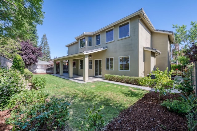 back of house featuring ceiling fan, a yard, a patio area, and a fenced backyard