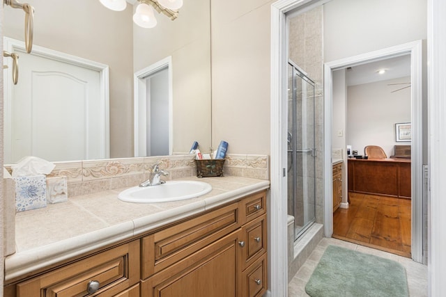 bathroom with tile patterned floors, connected bathroom, vanity, and a shower stall