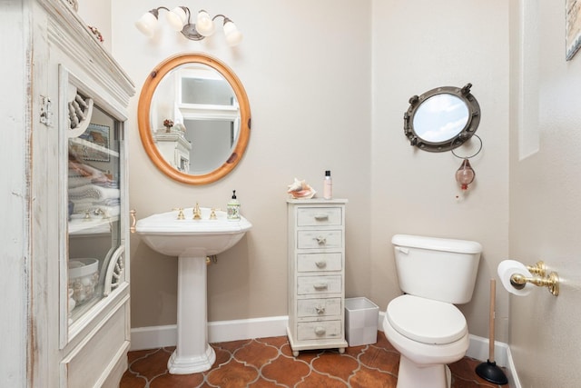 bathroom featuring tile patterned flooring, baseboards, and toilet