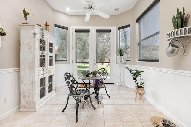 sunroom / solarium featuring plenty of natural light, ceiling fan, and french doors