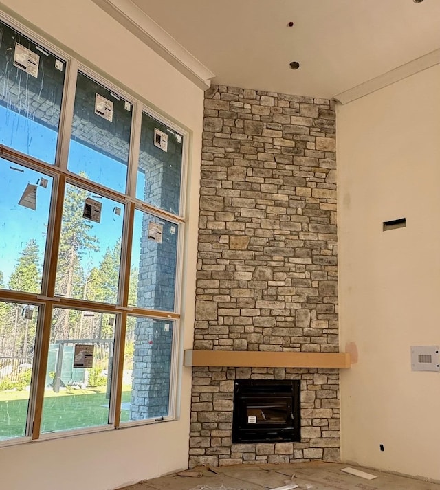 unfurnished living room with a fireplace and crown molding