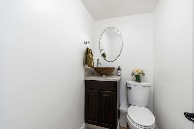 half bathroom featuring vanity and toilet