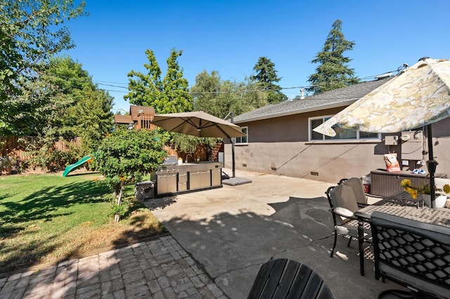 view of patio with exterior kitchen, a playground, and fence