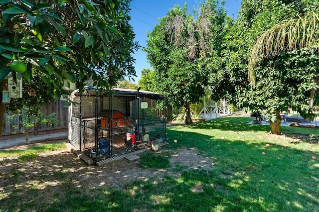 view of yard featuring an outbuilding, fence, and exterior structure