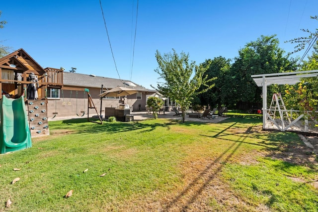 view of yard with a playground, fence, and a patio