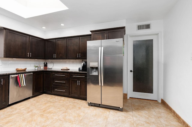 kitchen featuring light tile patterned floors, stainless steel appliances, tasteful backsplash, visible vents, and dark brown cabinetry