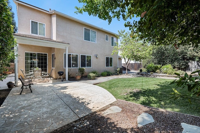 back of house featuring a yard, fence, a patio, and stucco siding