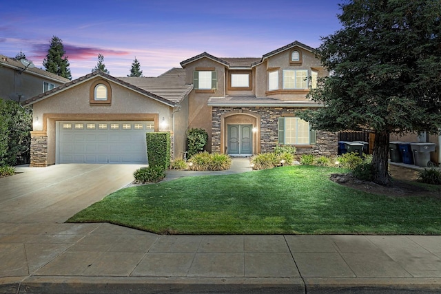 traditional-style house with driveway, a garage, a lawn, stone siding, and stucco siding