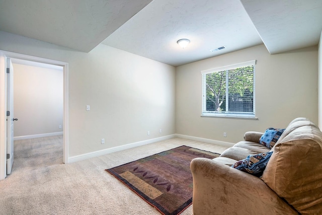 living area featuring baseboards, visible vents, and carpet flooring