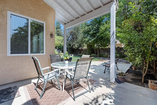 view of patio featuring outdoor dining area and fence