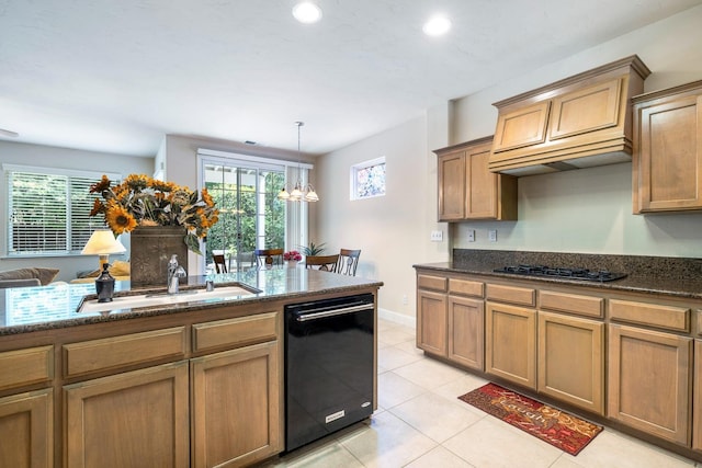 kitchen with dishwasher, dark stone countertops, plenty of natural light, and a sink