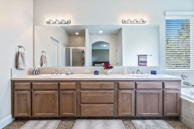 full bath featuring a stall shower, a sink, and double vanity