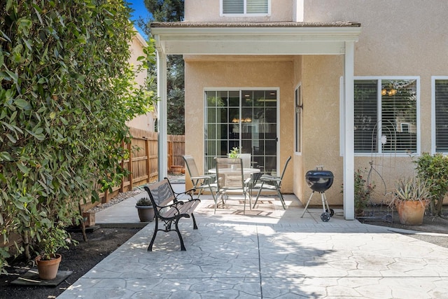 view of patio with outdoor dining space and fence