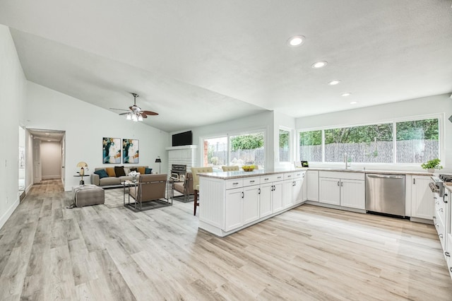 kitchen with lofted ceiling, open floor plan, white cabinets, dishwasher, and a peninsula