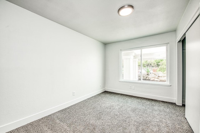 carpeted empty room with baseboards