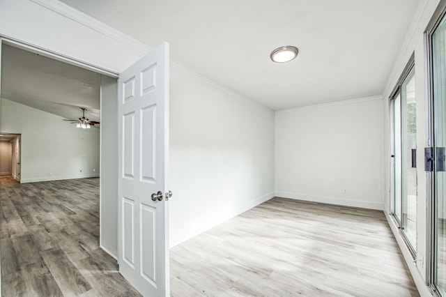 empty room featuring crown molding, baseboards, ceiling fan, and wood finished floors