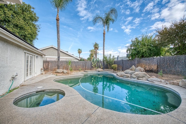 view of swimming pool with a fenced in pool, a patio, a fenced backyard, an in ground hot tub, and french doors