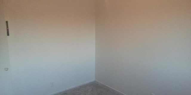 unfurnished room with baseboards