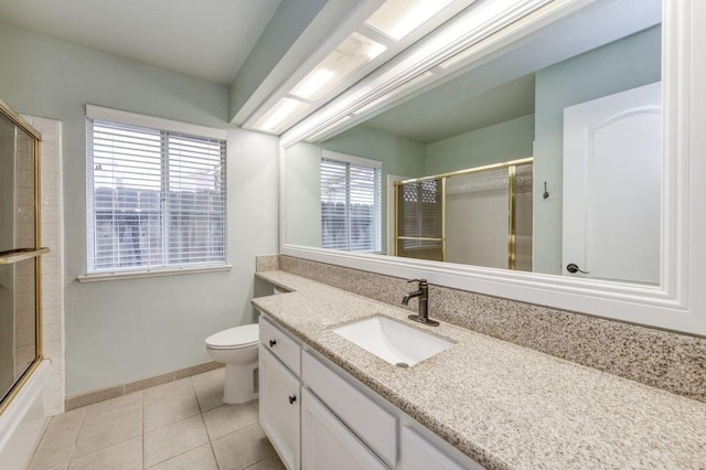 bathroom with tile patterned flooring, baseboards, vanity, and toilet