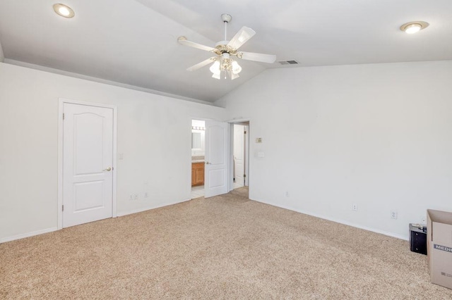 empty room with vaulted ceiling, ceiling fan, carpet flooring, and visible vents