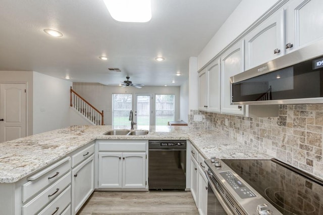 kitchen featuring visible vents, decorative backsplash, light stone counters, stainless steel appliances, and a sink