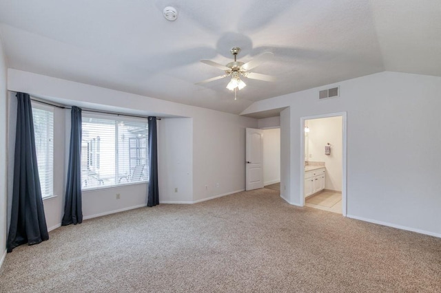 unfurnished bedroom featuring lofted ceiling, baseboards, visible vents, and light colored carpet