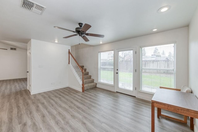 unfurnished living room featuring recessed lighting, visible vents, baseboards, light wood-style floors, and stairway