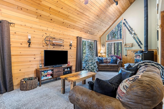 carpeted living room featuring a wood stove, wood ceiling, wooden walls, and high vaulted ceiling