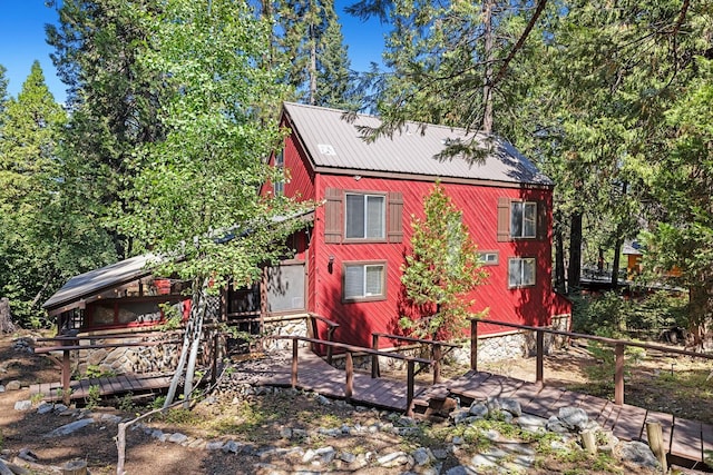 view of property exterior with metal roof and a wooden deck