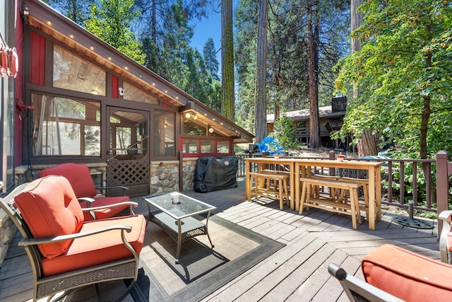wooden terrace with an outdoor hangout area and outdoor dining area
