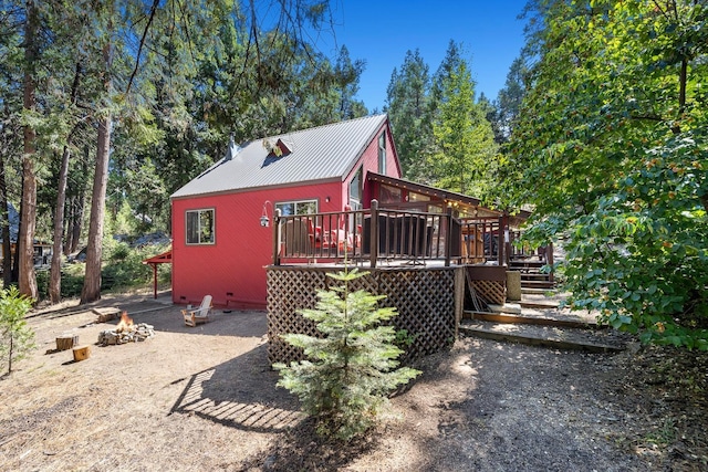 exterior space featuring a fire pit, metal roof, crawl space, stairs, and a deck