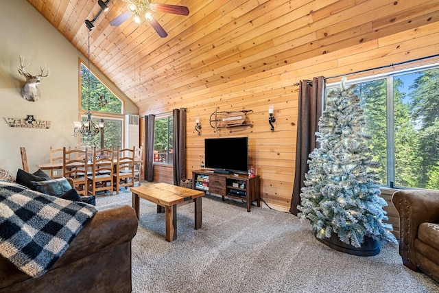 living room featuring carpet, wood ceiling, wooden walls, high vaulted ceiling, and ceiling fan with notable chandelier