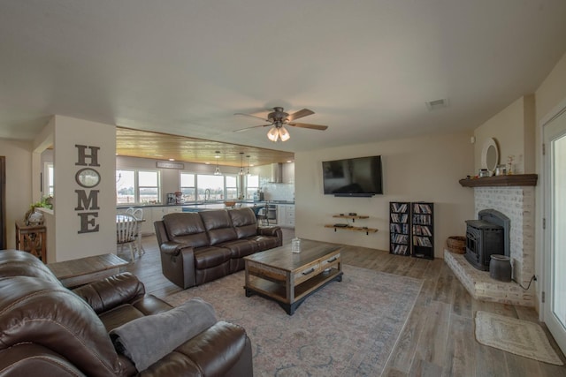 living area featuring visible vents, ceiling fan, and wood finished floors