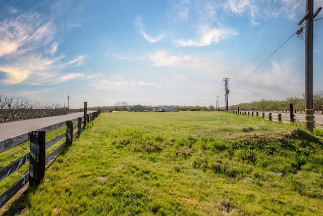 view of yard with a rural view and fence