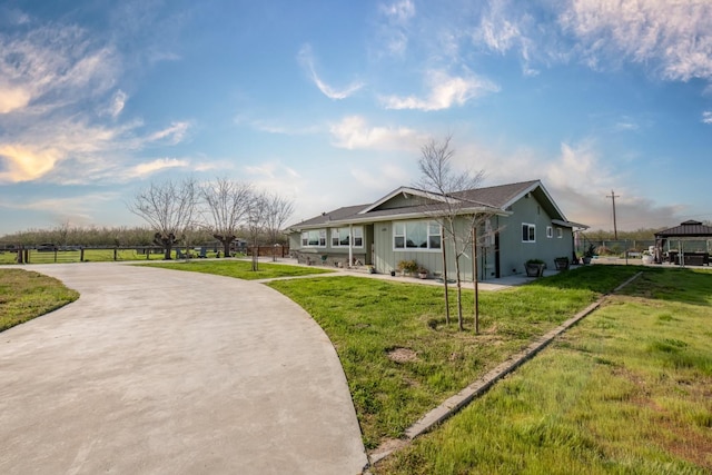 view of front of property featuring fence, a front lawn, and concrete driveway