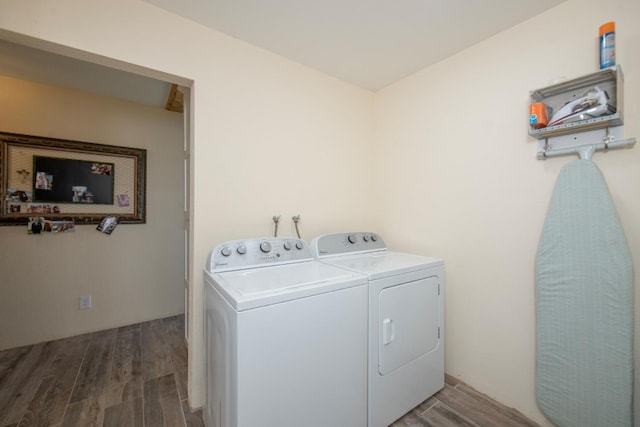 laundry area with laundry area, wood finished floors, and washing machine and clothes dryer