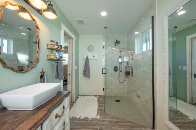 bathroom with a stall shower, recessed lighting, visible vents, and vanity