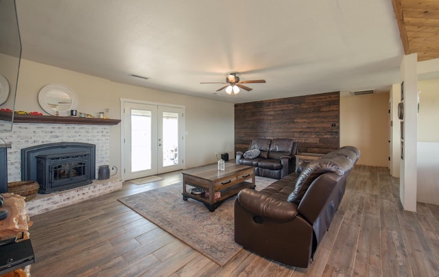 living area featuring a ceiling fan, french doors, visible vents, and wood finished floors