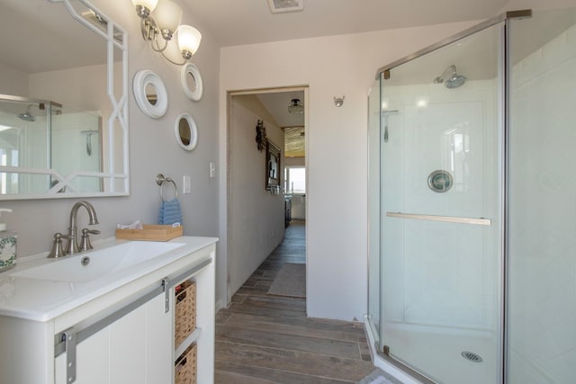 bathroom featuring a stall shower, vanity, and wood finished floors