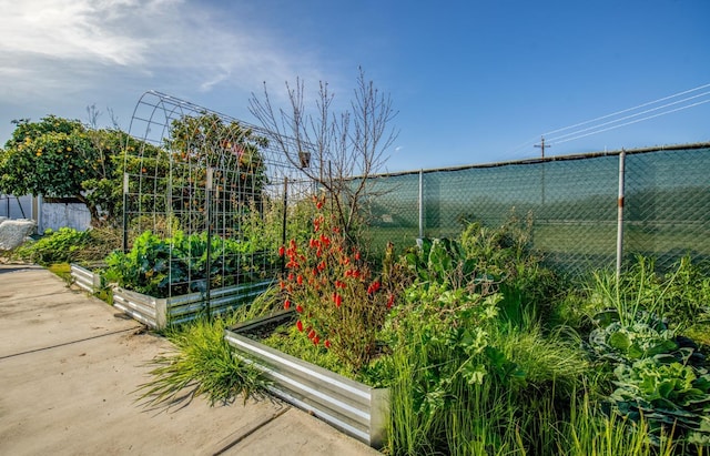 view of community with a garden and fence