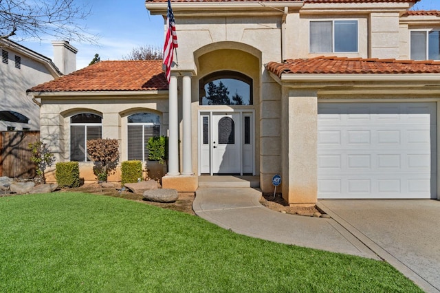 view of exterior entry with a garage, stucco siding, a chimney, and a tiled roof